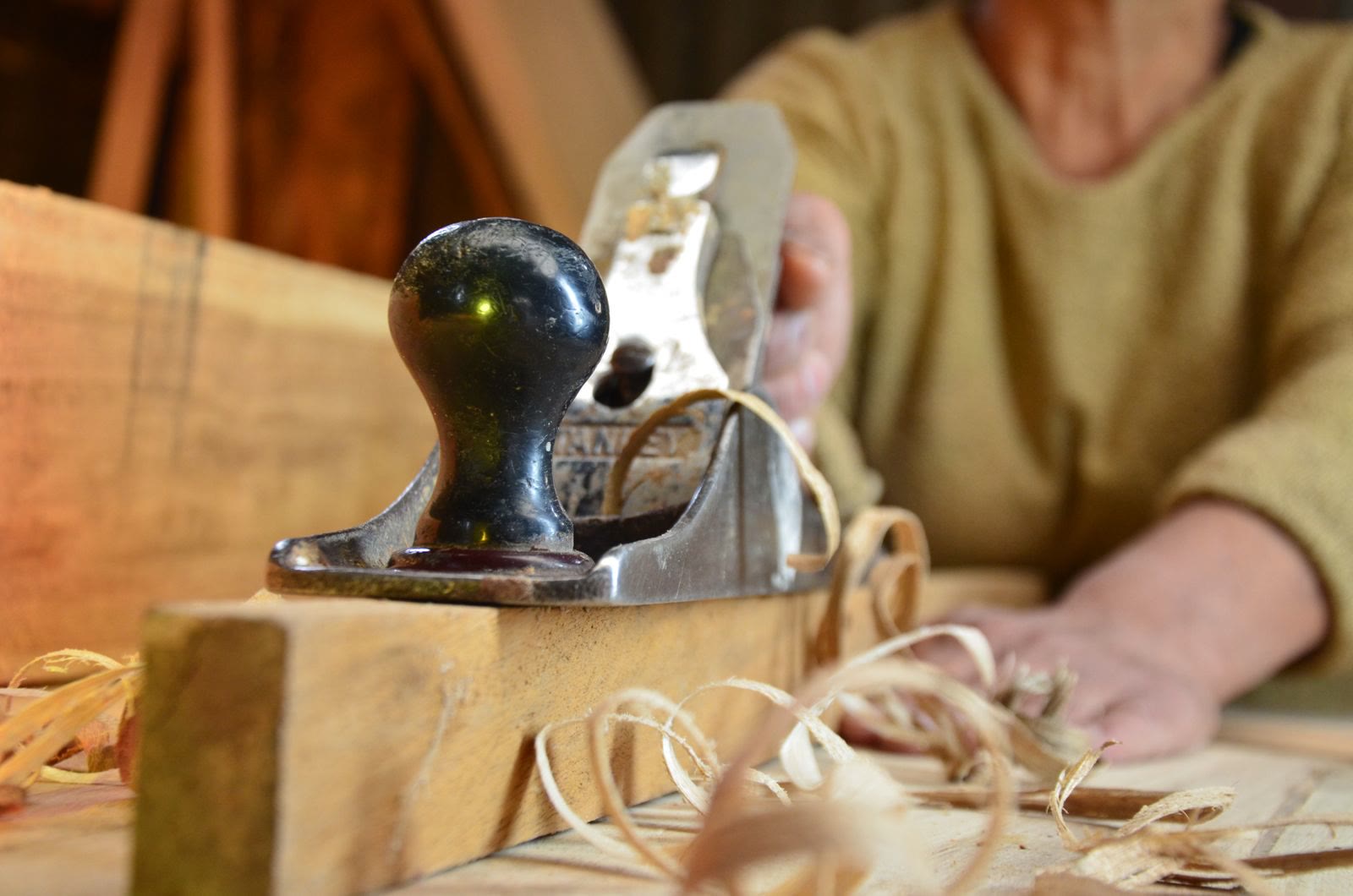 A hand plane and shavings on a joiner’s bench.