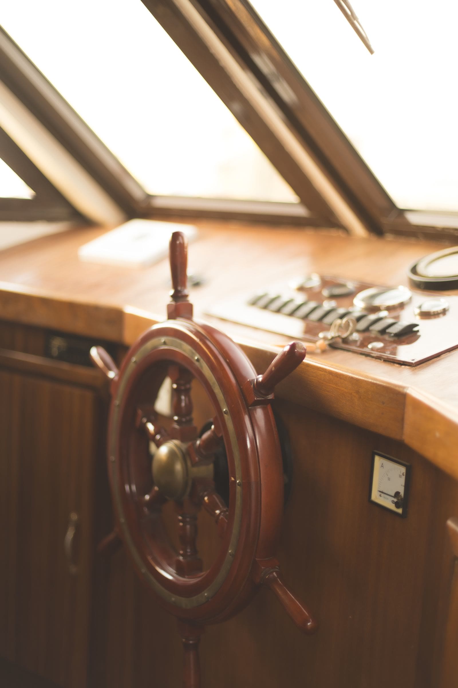 A timber and brass ship’s wheel on the helm station.