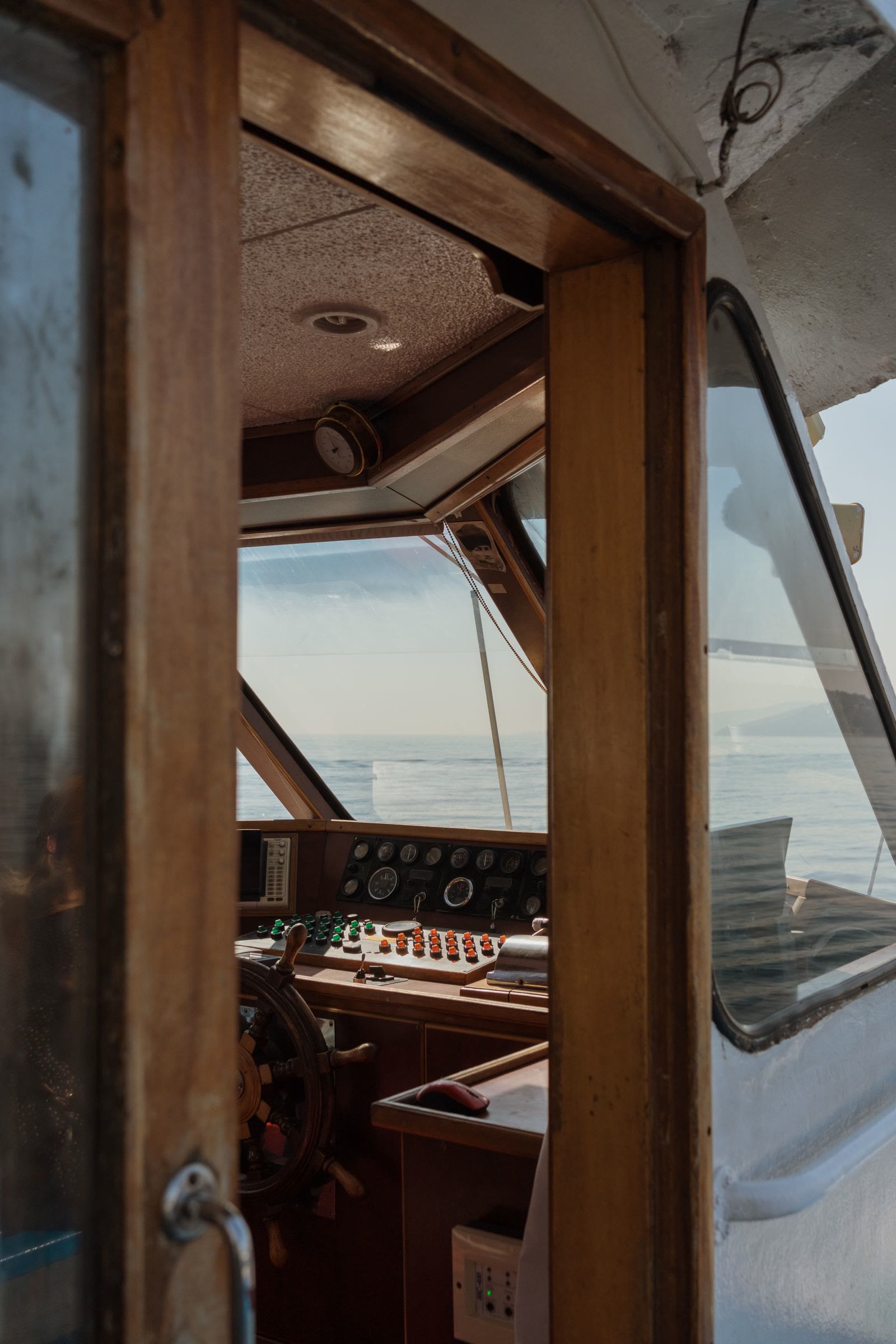 The timber helm cockpit with instruments, open to the sea.
